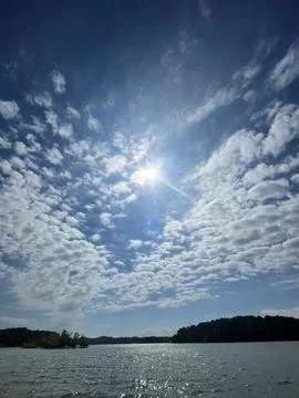 Sun Rays Through Dramatic Cloudy Sky Over Lake Foto stock