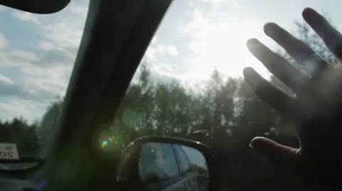 Sun rays through fingers and trees. Hand with rings on window of car on the go Stock Footage 67978138