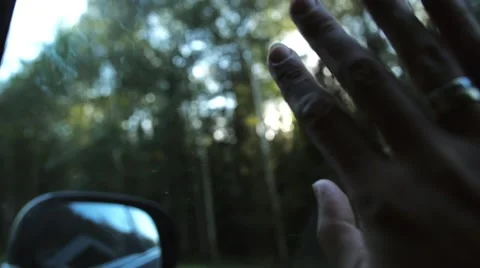Sun rays through fingers and trees. Hand with rings on window of car on the go Stock Footage 67978886