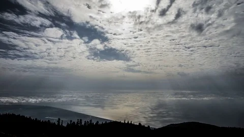 Sun rays through holes in the clouds moving from sea 库存影片 83793209