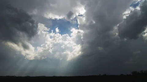 Sun rays through time-lapse white and stormy gray clouds sweep across the Stock Footage 59260725