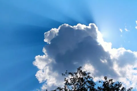 Sun rays through the white cloud in the blue sky Stock Photos