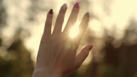 Sun rays through a woman's hand Stock Footage 76967936
