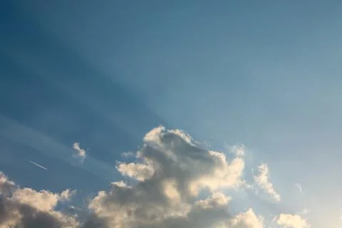 Sun Rays Touching Clouds Against a Beautiful Blue Sky Stock Photos