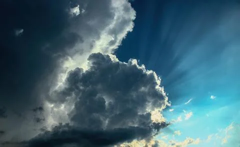 Sun rays from under the cloud. Light flux. Stock Photos