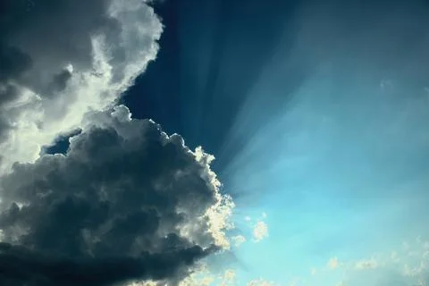 Sun rays from under the cloud. Light flux. Stock Photos