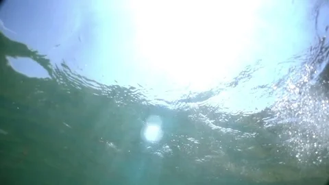 Sun rays visible through the surface of the ocean. Light flashes straight in the Stock Footage 80855428