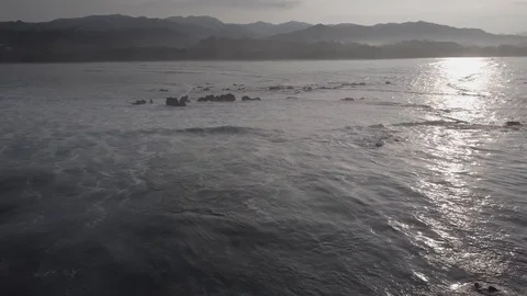 SUN REFLECS, SLOW WAVE CRASHES ROCKS | PART 01 OF 05 | EXT, AERIAL | 2398 | 4K Stock Footage 105256322