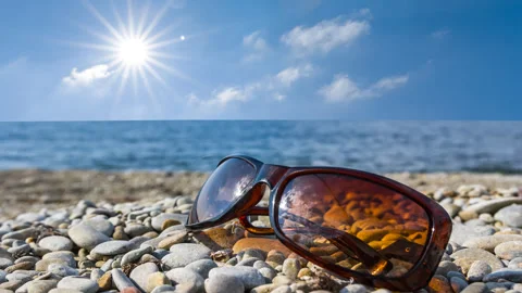Sun reflected in a glasses on a sea coast Vídeos de archivo 328712042