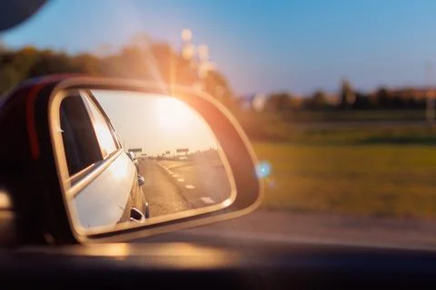The sun is reflected in the mirror, evening road. Stock Photos