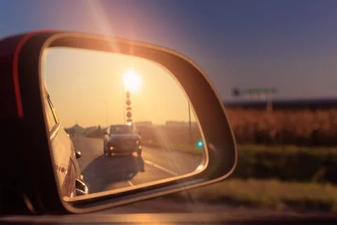 The sun is reflected in the mirror, evening road. Stock Photos