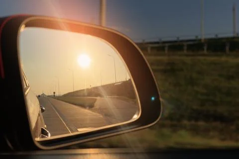 The sun is reflected in the mirror, evening road. Photos