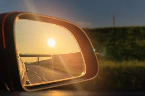 The sun is reflected in the mirror, evening road. Stock Photos