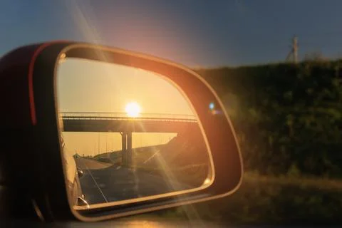 The sun is reflected in the mirror, evening road. Stock Photos