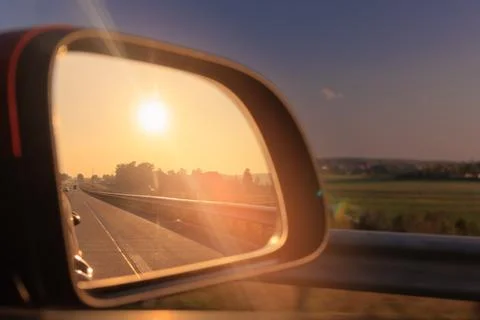 The sun is reflected in the mirror, evening road, side rear view mirror Stock Photos