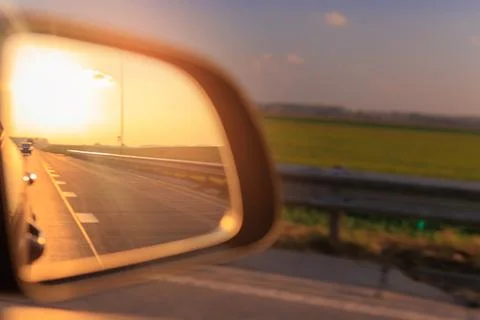 The sun is reflected in the mirror, evening road, side rear view mirror Stock Photos