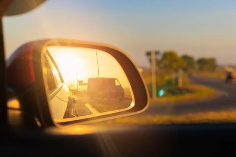 The sun is reflected in the mirror, evening road. Stock Photos