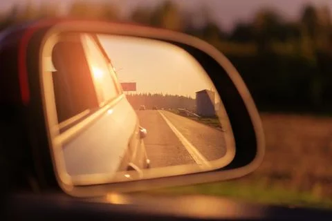 The sun is reflected in the mirror, evening road. Stock-Fotos