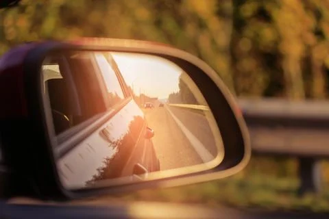 The sun is reflected in the mirror, evening road. Stock Photos