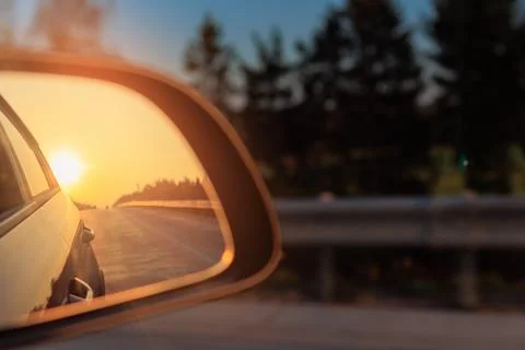The sun is reflected in the mirror, evening road. Stock Photos