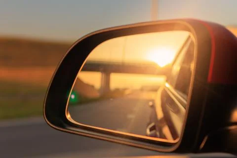 The sun is reflected in the mirror, evening road. Stock Photos