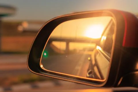 The sun is reflected in the mirror, evening road. Stock Photos