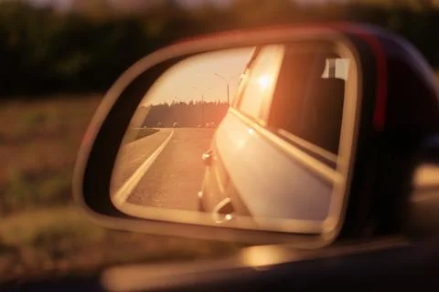 The sun is reflected in the mirror, evening road, side rear view mirror Stock Photos