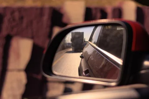 The sun is reflected in the side rear view mirror, evening road. Stock Photos