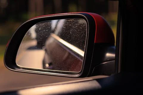 The sun is reflected in the side rear view mirror, evening road. Foto stock