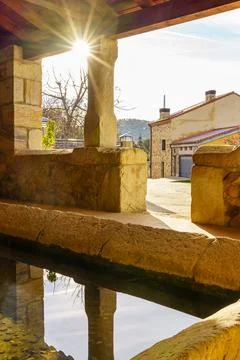 Sun reflected in the water of an old public laundry room to wash clothes in the Stock Photos