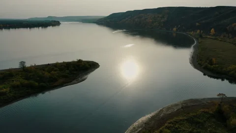 The sun is reflected in the wide river. Autumn landscape shot from a copter. Stock Footage 142923183
