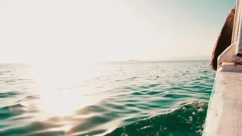 Sun reflecting on the sea surface as seen from the side of a cruising boat Stock Footage 312036840