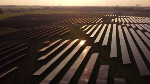 Sun reflecting on solar panel farm during aerial inspection at sunset. Video stock 163163434
