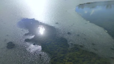 The sun reflecting on the surface of a winter pond Stock Footage 320328135