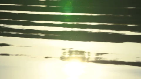 Sun reflecting in water surface at sunnset on the lake, nightfall in nature. Stockbeeldmateriaal 143897963