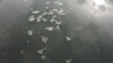 Sun reflecting in winter river water surface with ice flowing Stock Footage 303251952