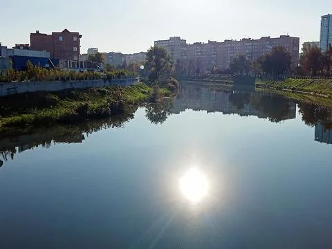 Sun reflection on calm city river Stock Photos