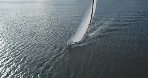 Sun reflection at closeup luxury yacht on ocean bay aerial. Wind white sails at Stock Footage 142310209