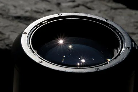 Sun Reflection in Pro Camera Lens with Flare on Black Stone Background Stock Photos