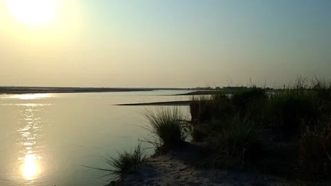 Sun Reflection On River Near Grassy Bank Vídeo Stock 334697390