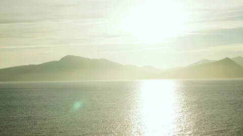 Sun reflection shimmering on the sea below mountains in Alaska Stock-Footage 348016526