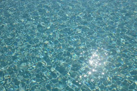 Sun reflection on the surface of a pool on a bright day Stock Photos