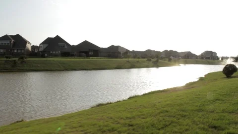 Sun Reflection in Water Next to Water Front Houses Stock Footage 91017346