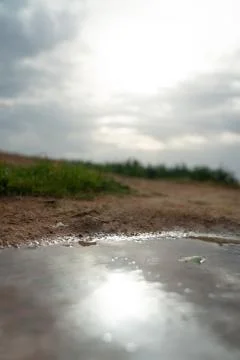 Sun reflection in water puddle Stock Photos