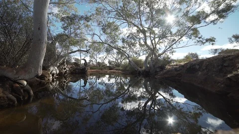 Sun reflection on waterhole in the outback of Australia Stock Footage 91699510