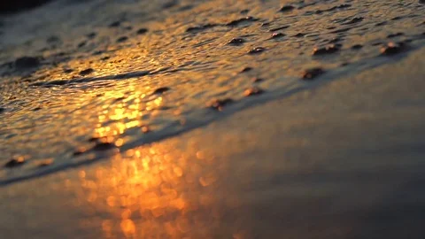 Sun reflections on a beach waves at sunset with bokeh Stock Footage 77543951