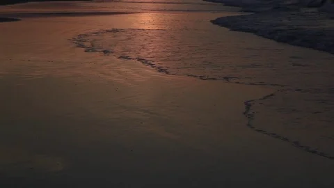 The sun reflects against small waves crashing on the beach Video stock 74665229