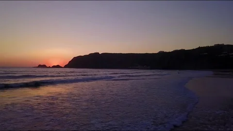Sun reveal behind rocks on beach Video stock 78072633