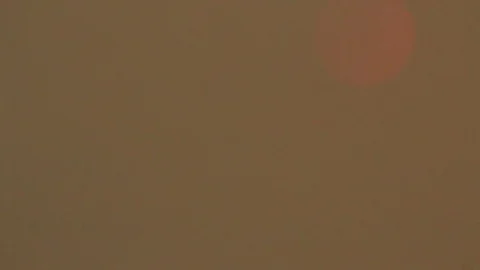 Sun revealed behind smoke Stock Footage 78554408