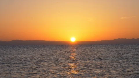 Sun rise behind the mountains and the sea Stock Footage